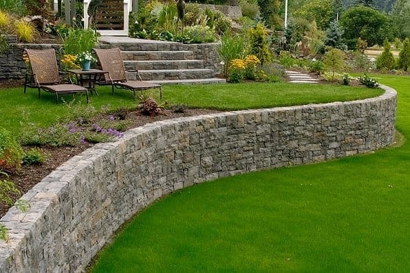 curved retaining wall with green grasss